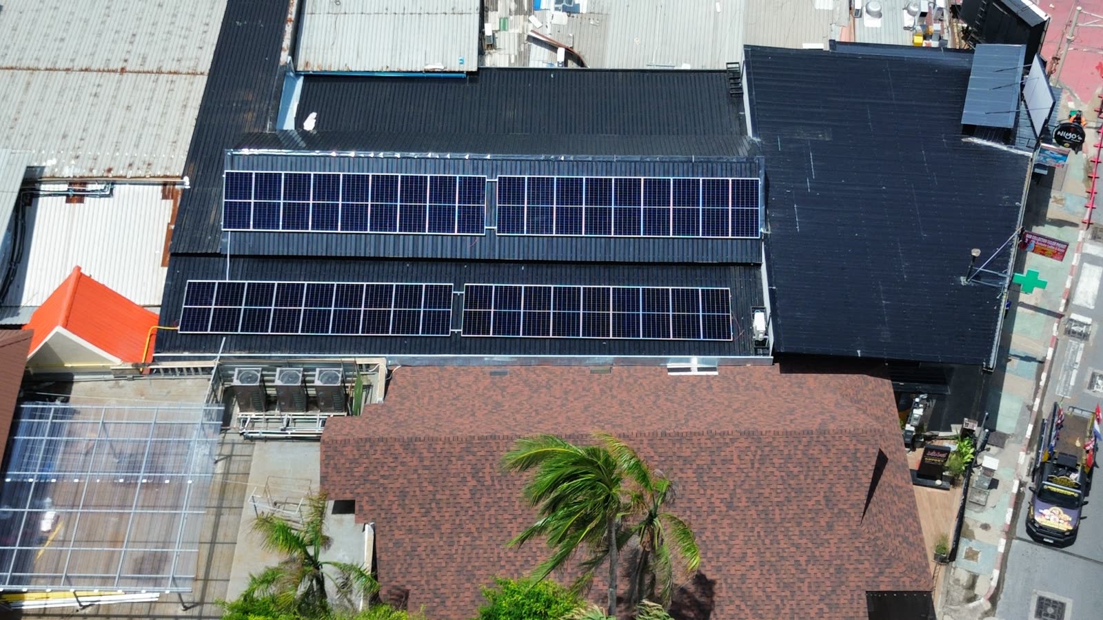ภาพมุมสูงแผงโซลาร์เซลล์บนหลังคาภัตตาคารเสวย ป่าตอง ภูเก็ต ระบบไฮบริด 20 kW พร้อมแบตเตอรี่ 32 kWh